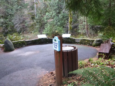 Salmon River viewing area is paved – rock wall with interpretive signage – bench – sign “Big Fish of the River”